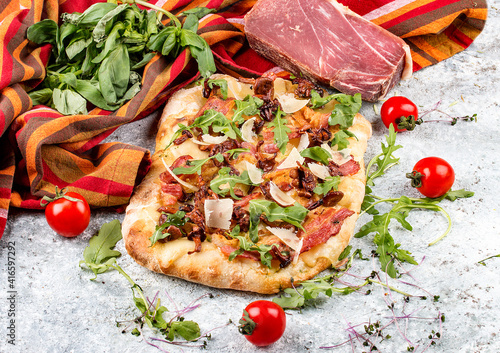 Roman pizza. Carbonara pinza with bacon, arugula and chanterelles. Top view