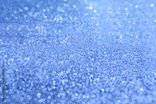 Blue blurred background with highlights and fine texture of shiny crystals