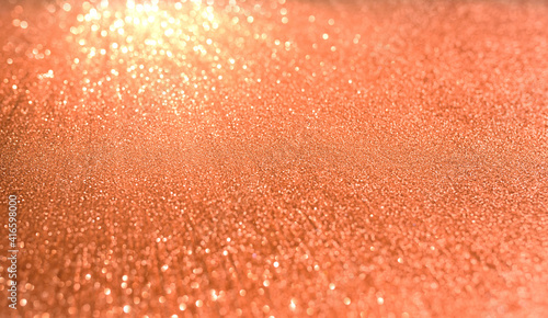 Orange blurred background with highlights and fine texture of shiny crystals