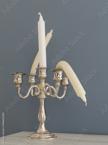 Candlestick with straight and bent candles. Metaphor of erectile dysfunction impotence. Creative concept of male potency problems. Sexual dysfunction in men, problems with health.