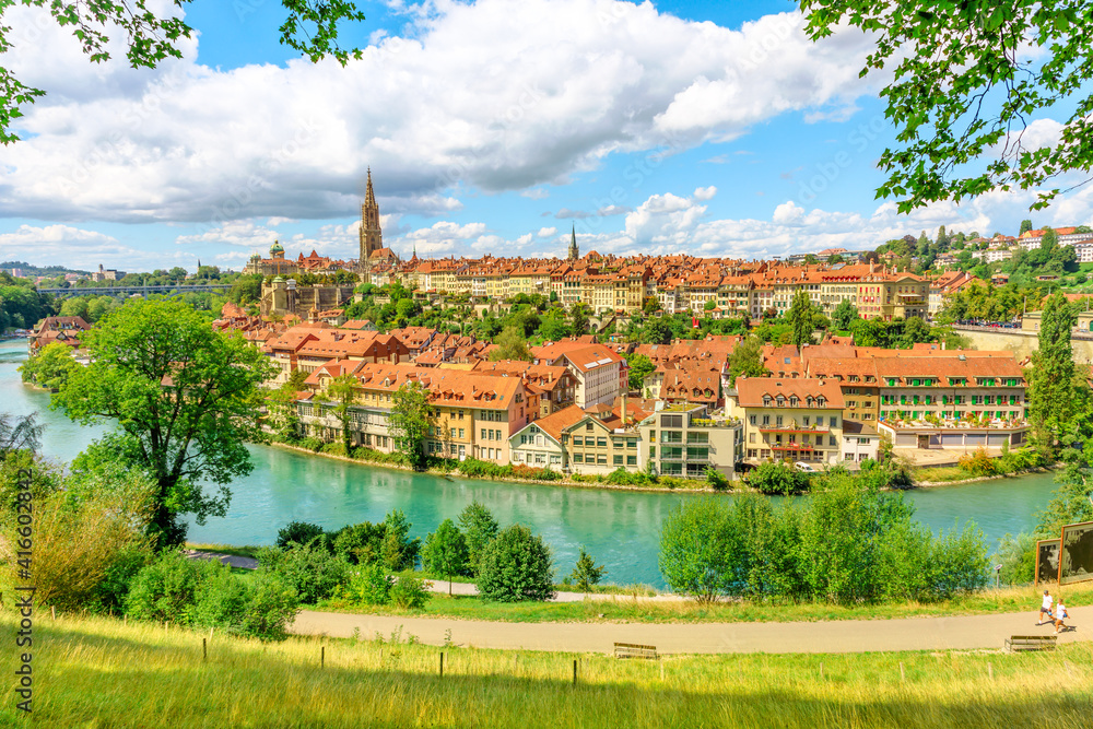Aerial view of cityscape of old town of Bern, Switzerland, with Cathedral Bell Tower and Aare river. Popular landmark of historical town UNESCO World Heritage. Skyline of medieval houses.