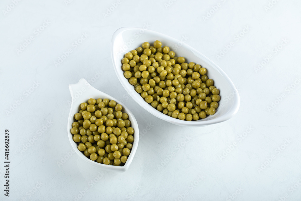 Two white bowls full with green marinated olives Two white bowls full with green marinated olives