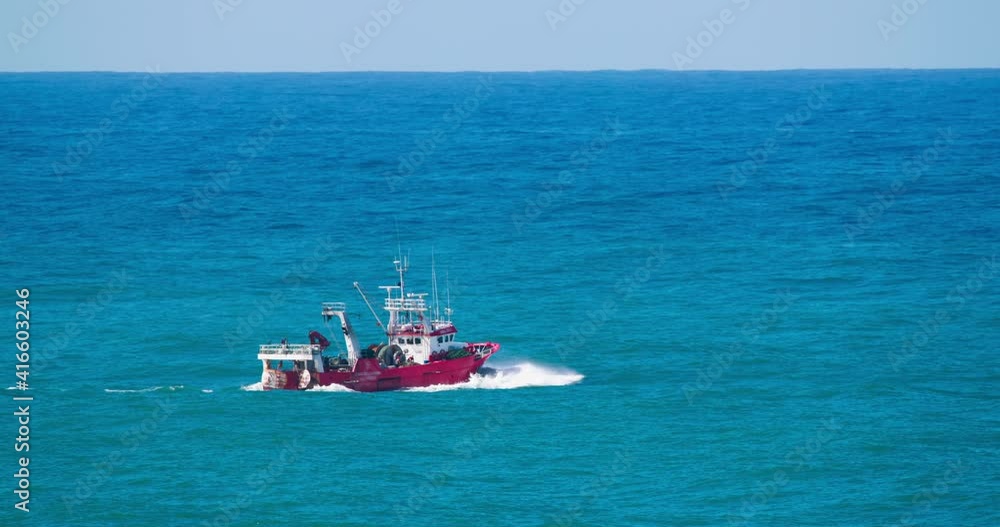 Small boat sailing in open waters of atlantic ocean. Commercial vessel floating in the harbor of Nazare, Portugal, Europe. Fishing boat going out to fish. 4k footage in slow motion Small boat sailing in open waters of atlantic ocean. Commercial vessel floating in the harbor of Nazare, Portugal, Europe. Fishing boat going out to fish. 4k footage in slow motion