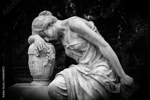 Sad and weeping woman sculpture. Sad grieving expression sculpture with sorrow face down thinking crying. Black and white BW photography.