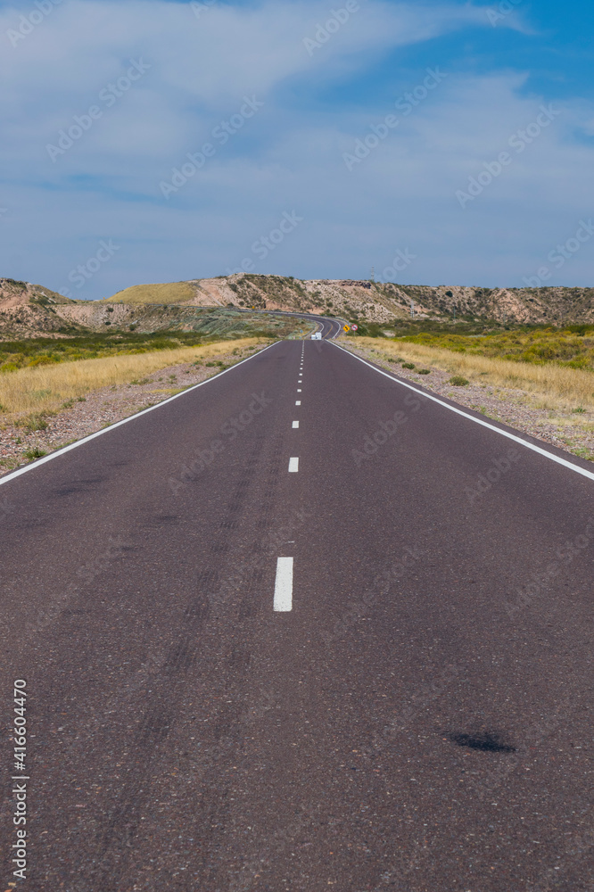 Ruta 40 Argentina. Carretera entre llanuras y mesetas, con un cielo vistoso