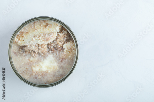 Canned beef. Open tin on white background