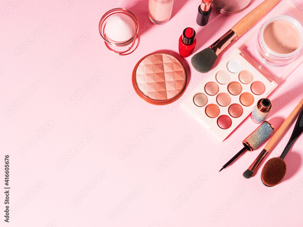 Fototapeta Different make up beauty cosmetics products on pink pastel background. Foundation, lipstick, eye shadows, brushes, face powder, eyeliner