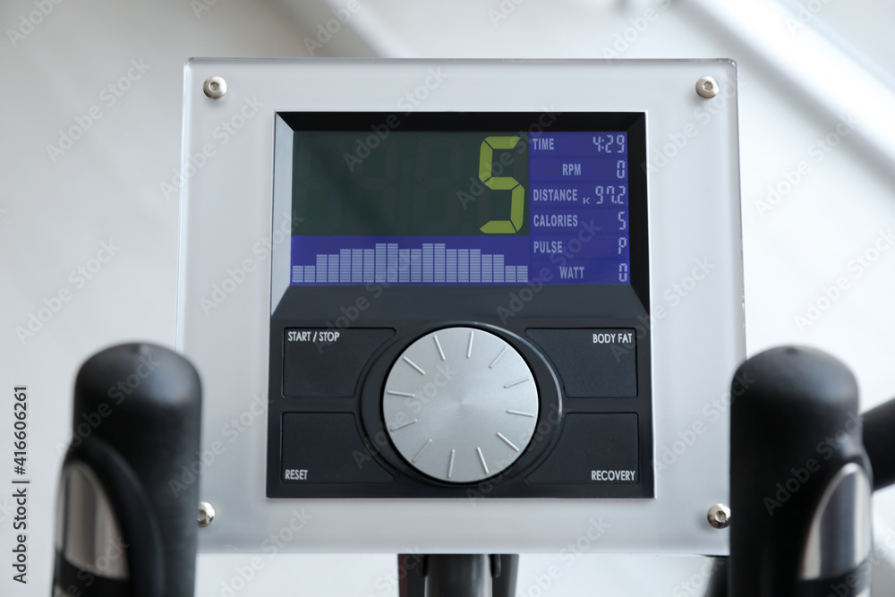 Control panel of modern elliptical machine cross trainer on blurred background