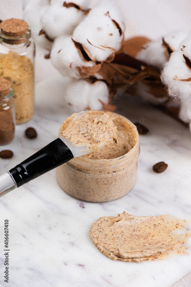 Fototapeta premium Natural body coffee scrub on marble background. Cosmetic face cream container with care cruelty-free product. Flat lay, top view