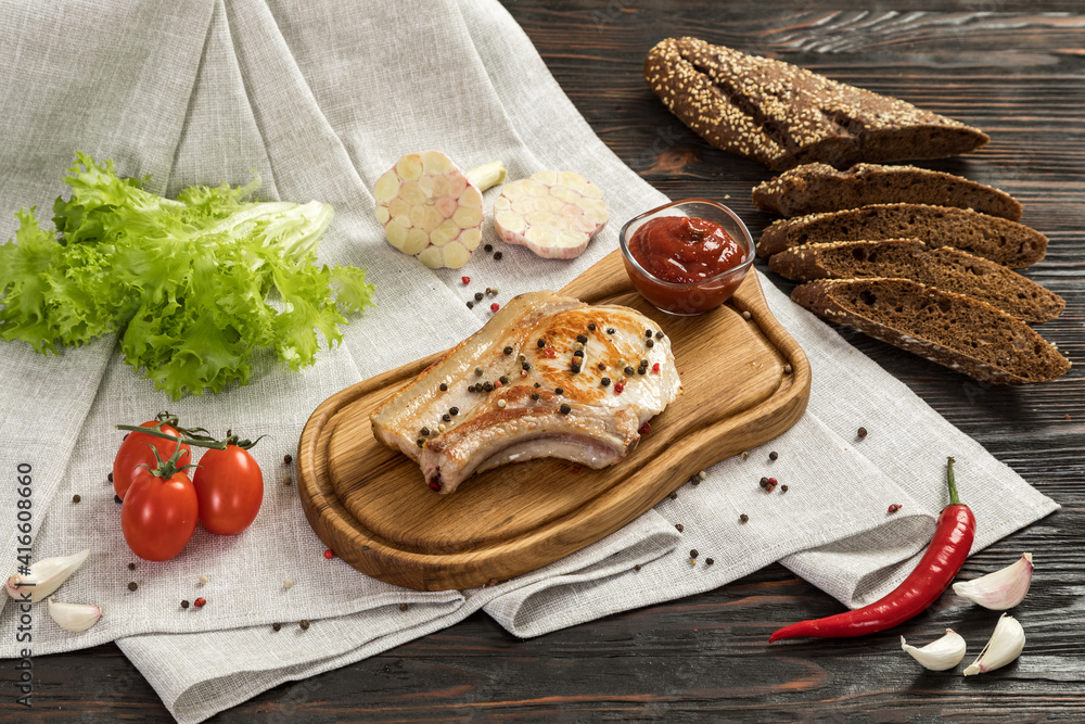 Fried pork entrecote on a board for serving.