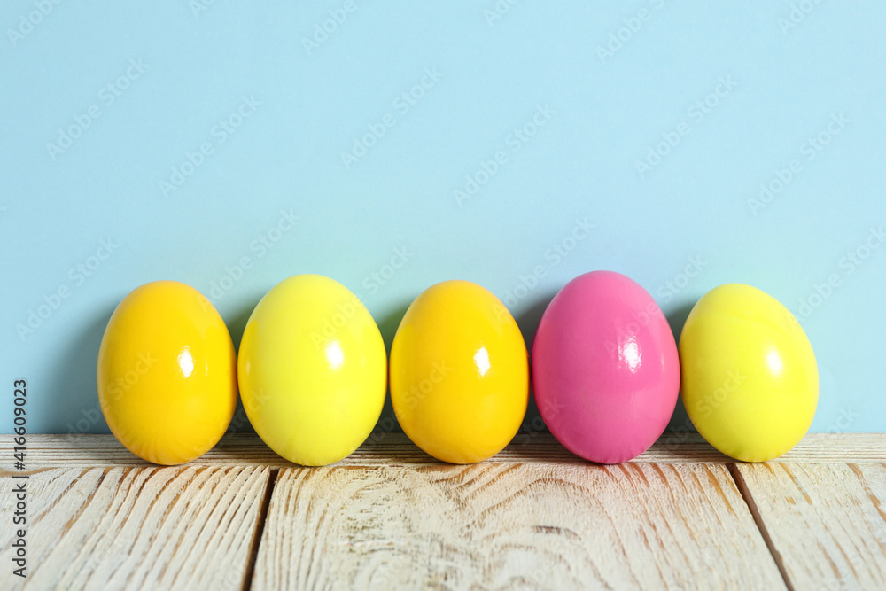 Easter eggs on white wooden table against light blue background, space for text Easter eggs on white wooden table against light blue background, space for text