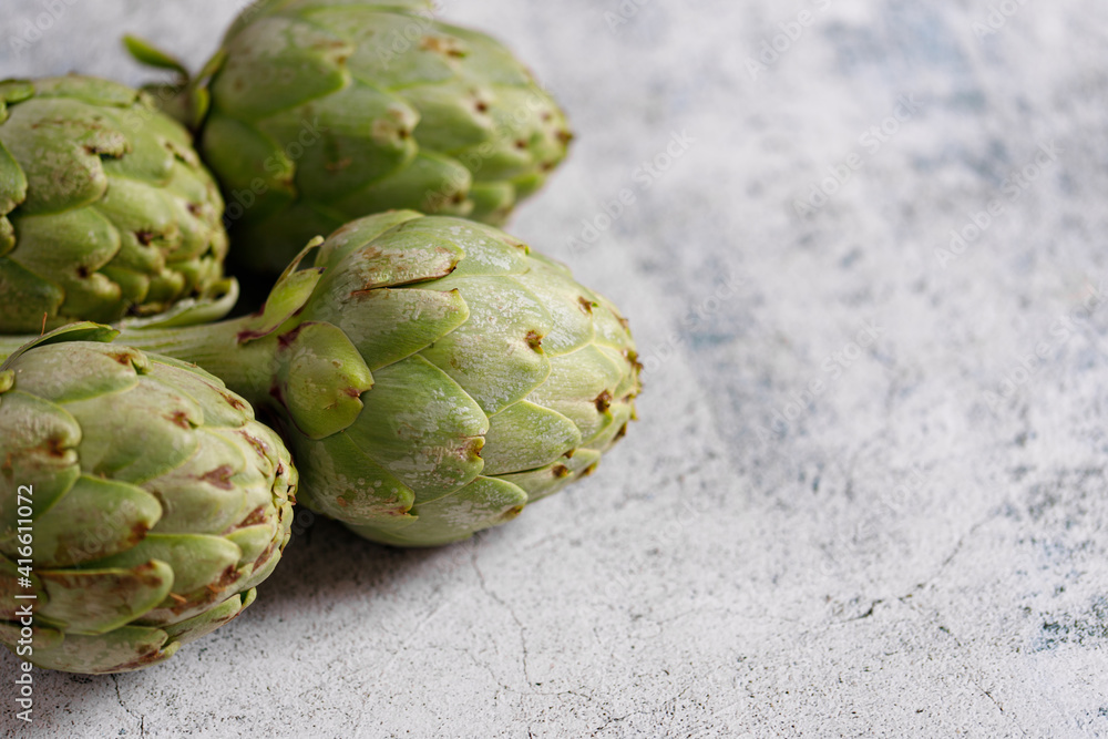 Fototapeta premium artichokes on grey background. fresh organic artichoke flower