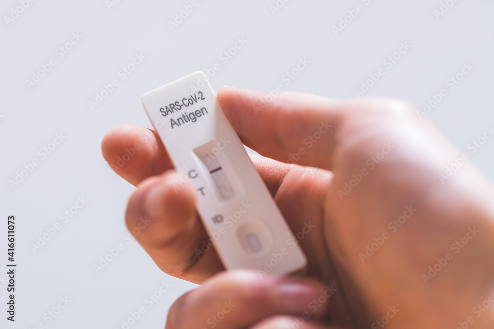 Express corona test at home: Close up of fingers holding a negative covid antigen test Express corona test at home: Close up of fingers holding a negative covid antigen test