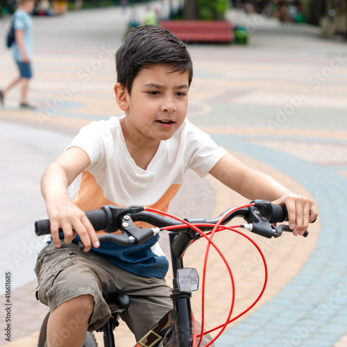 Young boy rids a bicycle outdoors on vacation