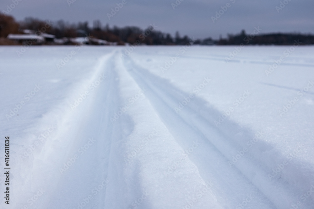 Cross-country wild ski track lines close-up on snow going forward in evening blue light. Active sport recreation in winter Cross-country wild ski track lines close-up on snow going forward in evening blue light. Active sport recreation in winter