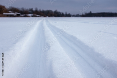 Cross-country wild ski track lines close-up on snow going forward in evening blue light. Active sport recreation in winter