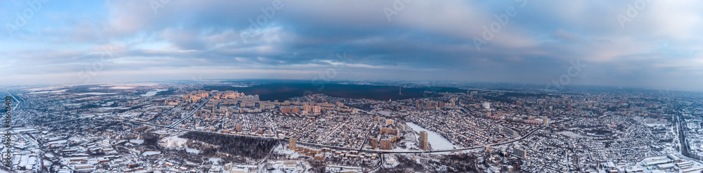 Aerial panoramic view of winter Kharkiv city Shevchenkivskyi district with urban view and residential multistorey buildings with scenic colorful cloudy sky in winter
