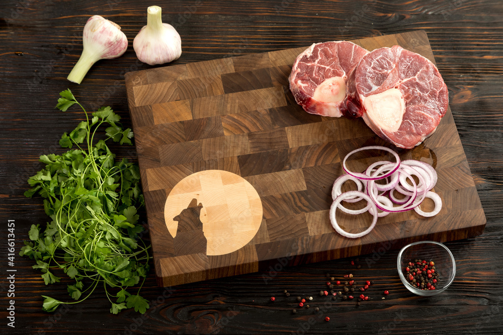 Raw piece of beef with herbs on a cutting board.