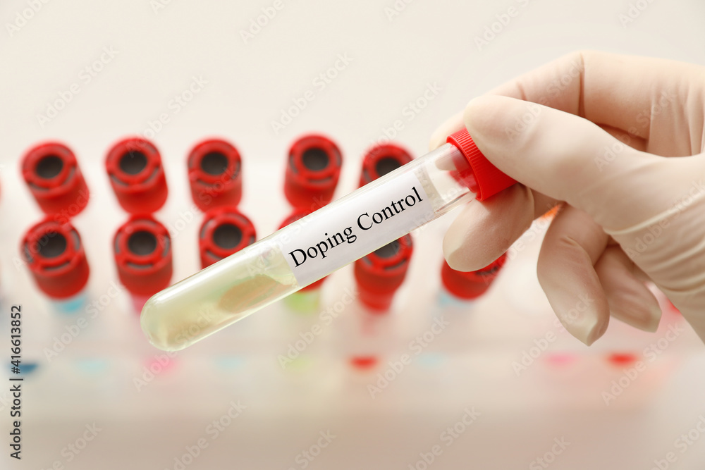 Fototapeta premium Doctor holding test tube with sample over table, closeup. Doping control