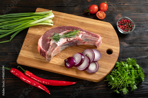 Obraz na płótnie Raw piece of beef with herbs on a cutting board. w salonie