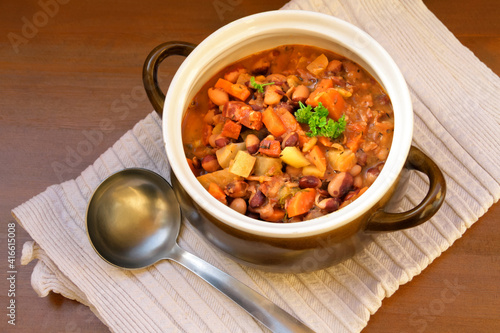 Suppe von Calypso-Bohnen Chorizo und Gemüse im Topf mit Kelle photo