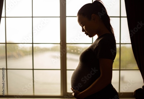 A pregnant mother thinking about her baby, tired alone at home. Depression and stress.