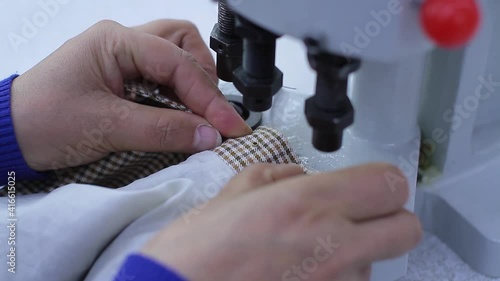 Sewing production. Machine for rivets on clothes.