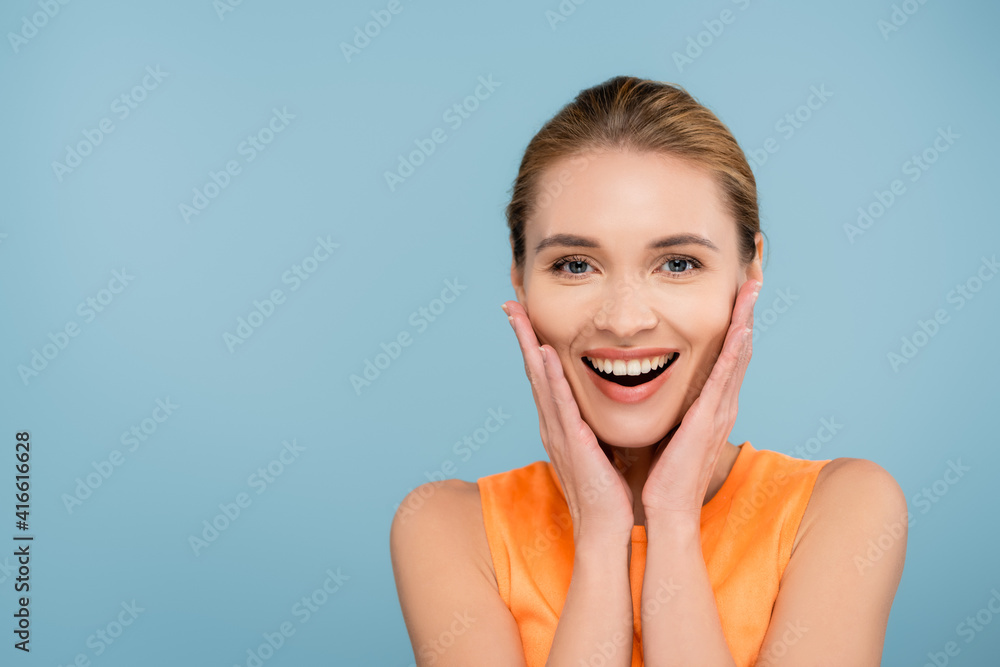 pretty young woman with natural makeup touching face isolated on blue pretty young woman with natural makeup touching face isolated on blue