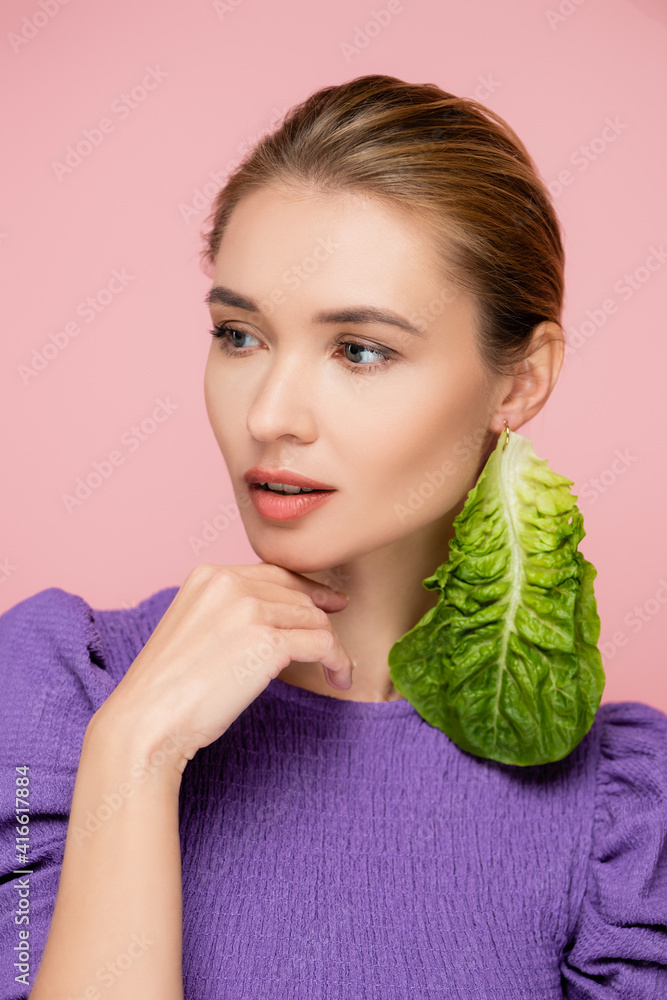 charming woman with natural makeup, wearing green lettuce earring isolated on pink charming woman with natural makeup, wearing green lettuce earring isolated on pink