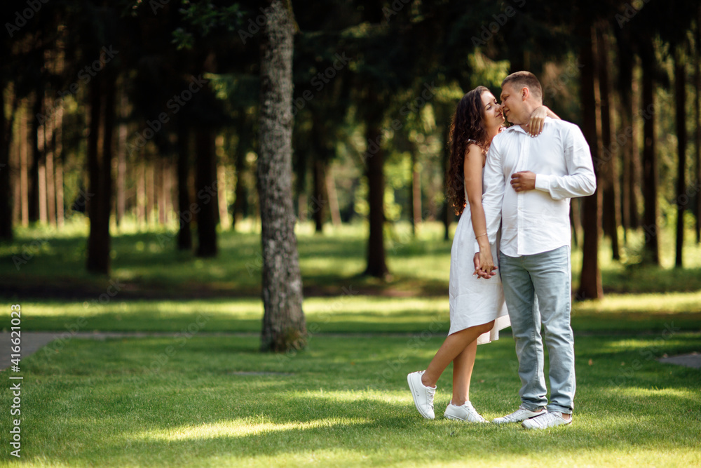 young couple in love is hugging in the park on a summer day. man and woman outdoors