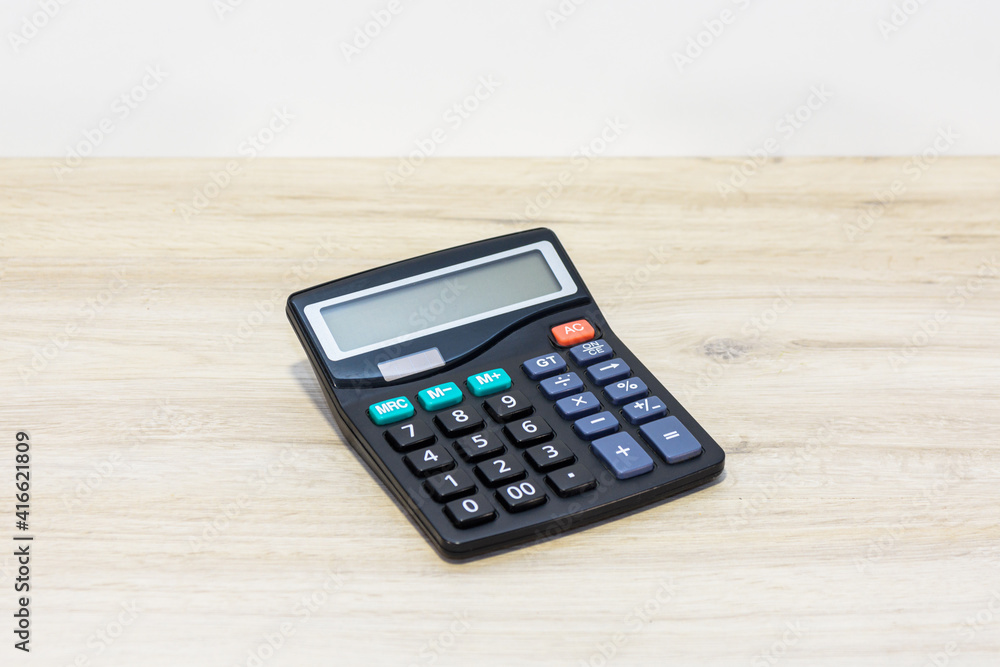 Black calculating calculator on the office table. Calculator for calculating the balance in accounting. Black calculating calculator on the office table. Calculator for calculating the balance in accounting.
