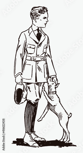 Standing boy from early 20th century wearing knickerbockers, holding cap and playing with his dog