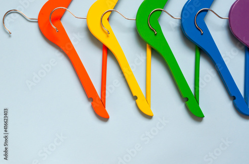 Multi-colored clothes hangers on a blue background. Concept of shopping and sale. photo