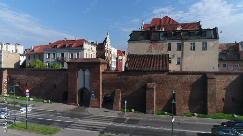 The walls of the old town in Toruń and historic tenement houses with red roofs. Beautiful sunny and summer day with a blue sky. The walls of the old town in Toruń and historic tenement houses with red roofs. Beautiful sunny and summer day with a blue sky.