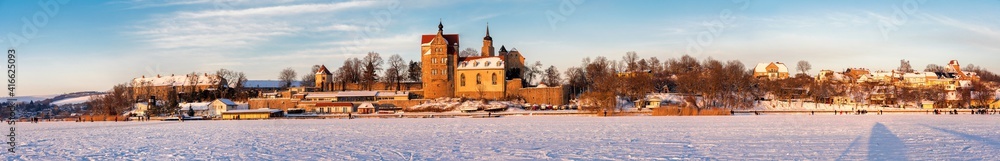Wunderschönes breites Panorama eines zugefrorenen See mit traumhaften Schloss und winterlicher Natur