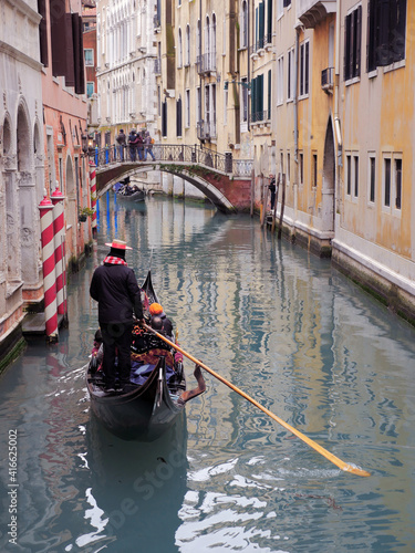 Gondolier sails through the canals of Venice. Happy sea man carries a gondola around Venice, Italy.