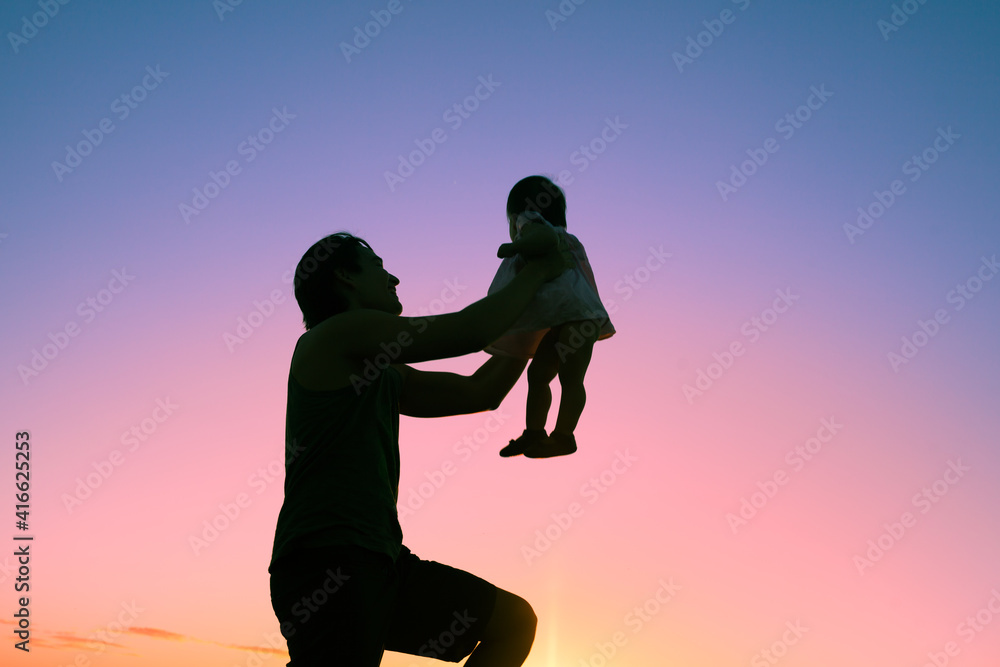 silhouette of happy father holding his child up in the air. 