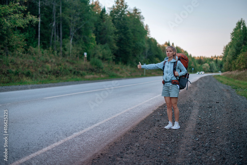 Travel woman with backpack hitchhiking on road © grthirteen