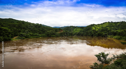 Huallaga river of the Peruvian high jungle. River among vegetation with light blue sky and white clouds.