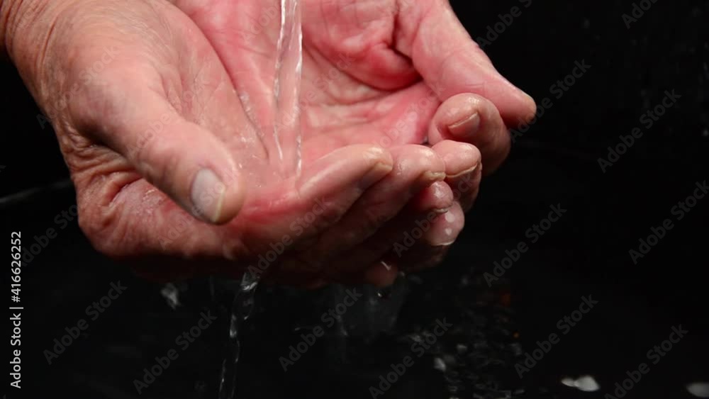 Old palms with water close-up. Children's hands pour water into old palms. Water seeps through children's fingers. Water seeping through grandma's old fingers. The concept of the transience of time. Old palms with water close-up. Children's hands pour water into old palms. Water seeps through children's fingers. Water seeping through grandma's old fingers. The concept of the transience of time.
