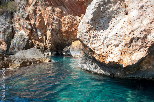 cliffside with limpid turquoise seawater, an idyllic place for scuba diving and spearfishing. photo