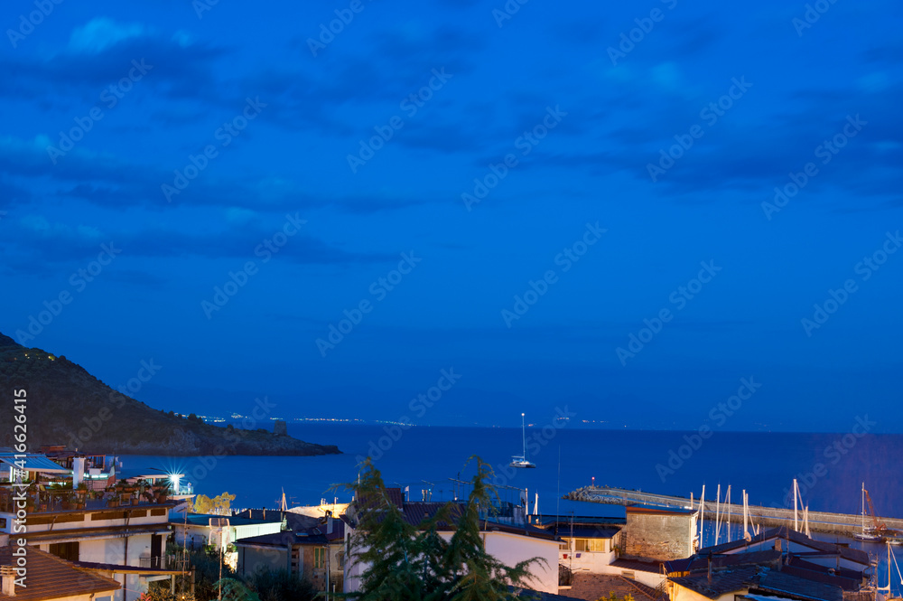 Picturesque bluish view with sky blending with the sea of the Marina di Camerota bay at twilight, Italy.
