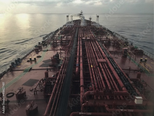 A ship is underway at sea, pictured from the bridge wings of the ship in the morning