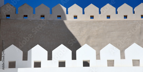 Zwei Linien mit verzierten Mauerzinnen vor strahlend blauem Himmel photo