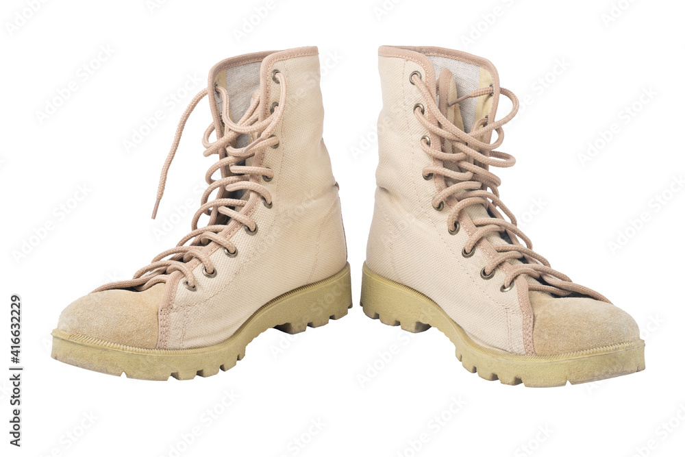 Old sandy beige tracking boots on white background. Isolated. Old sandy beige tracking boots on white background. Isolated.