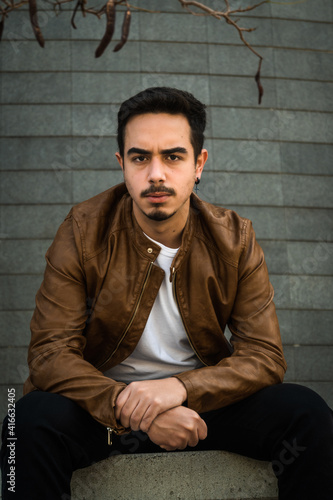 Boy in brown leather jacket posing