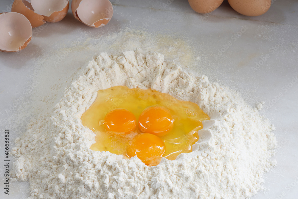 Raw chicken egg and flour on white background, homemade pasta. Raw chicken egg and flour on white background, homemade pasta.