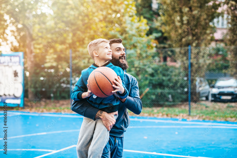 Obraz premium Father and his son enjoying together on basketball court.