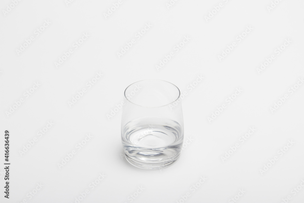 The half full glass of pure water isolated on a white background. A drinking glass half filled with water. A half empty glass with water. The half full glass of pure water isolated on a white background. A drinking glass half filled with water. A half empty glass with water.