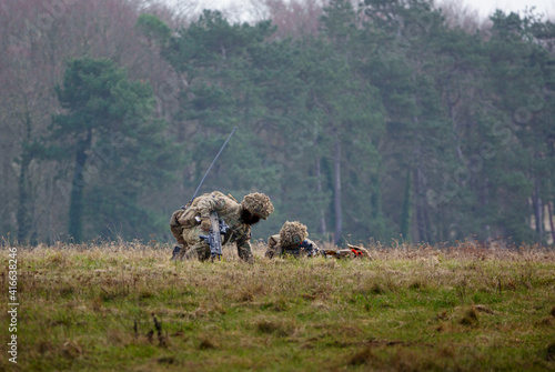 Royal Gurkha Rifles soldiers in full battle gear exercise in a demonstration of firepower, Salisbury Plain, Wiltshire  photo